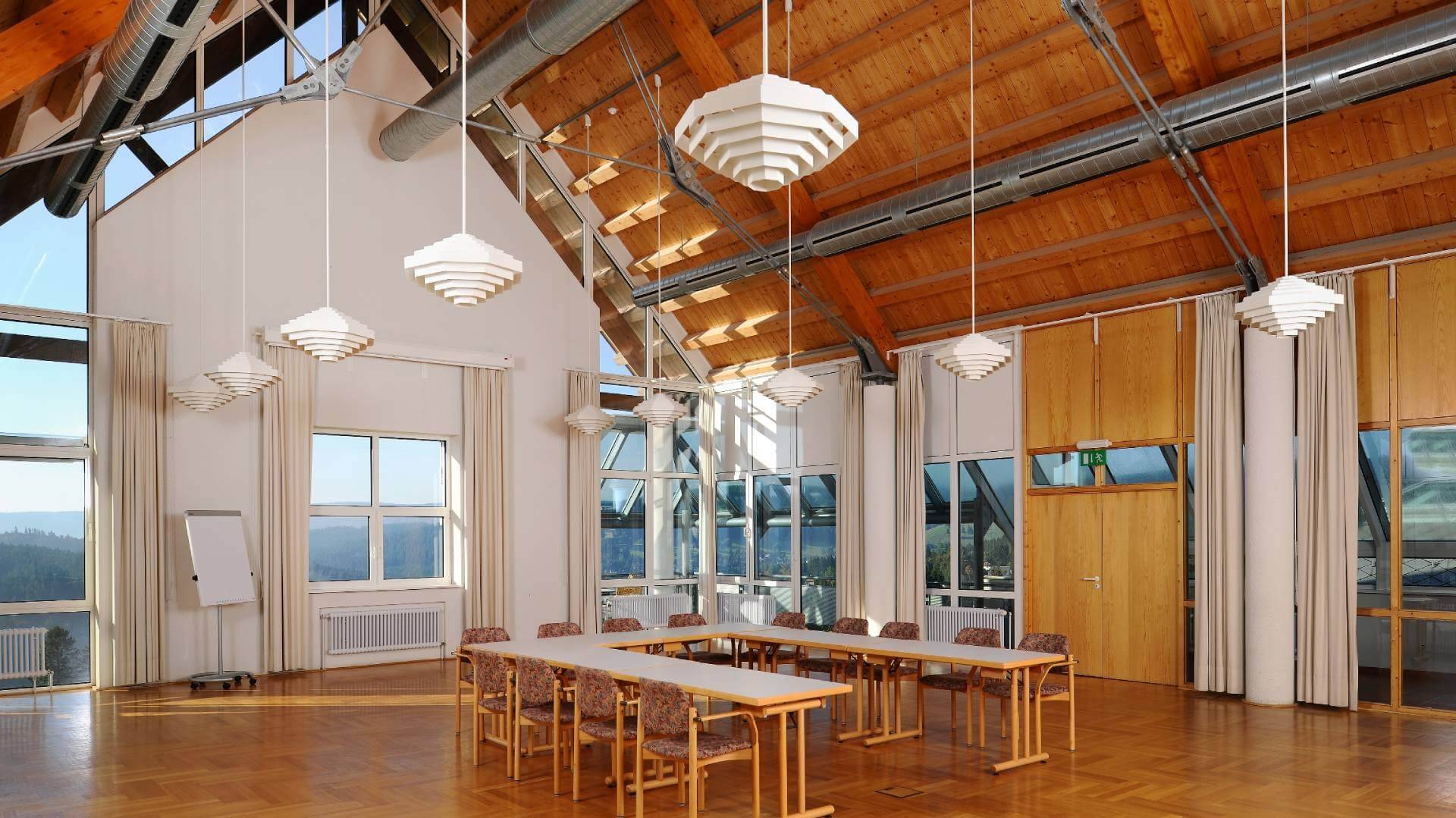 Großer Saal mit hohen Decken und Tischen - Haus Feldberg Falkau