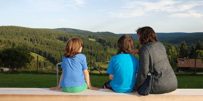 Familie auf einer Bank mit Schwarzwaldblick